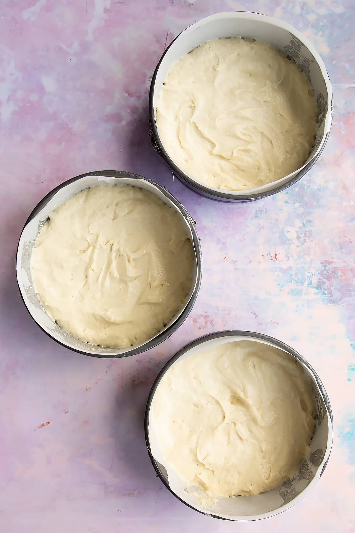 Vegan cake batter in a three lined tins.