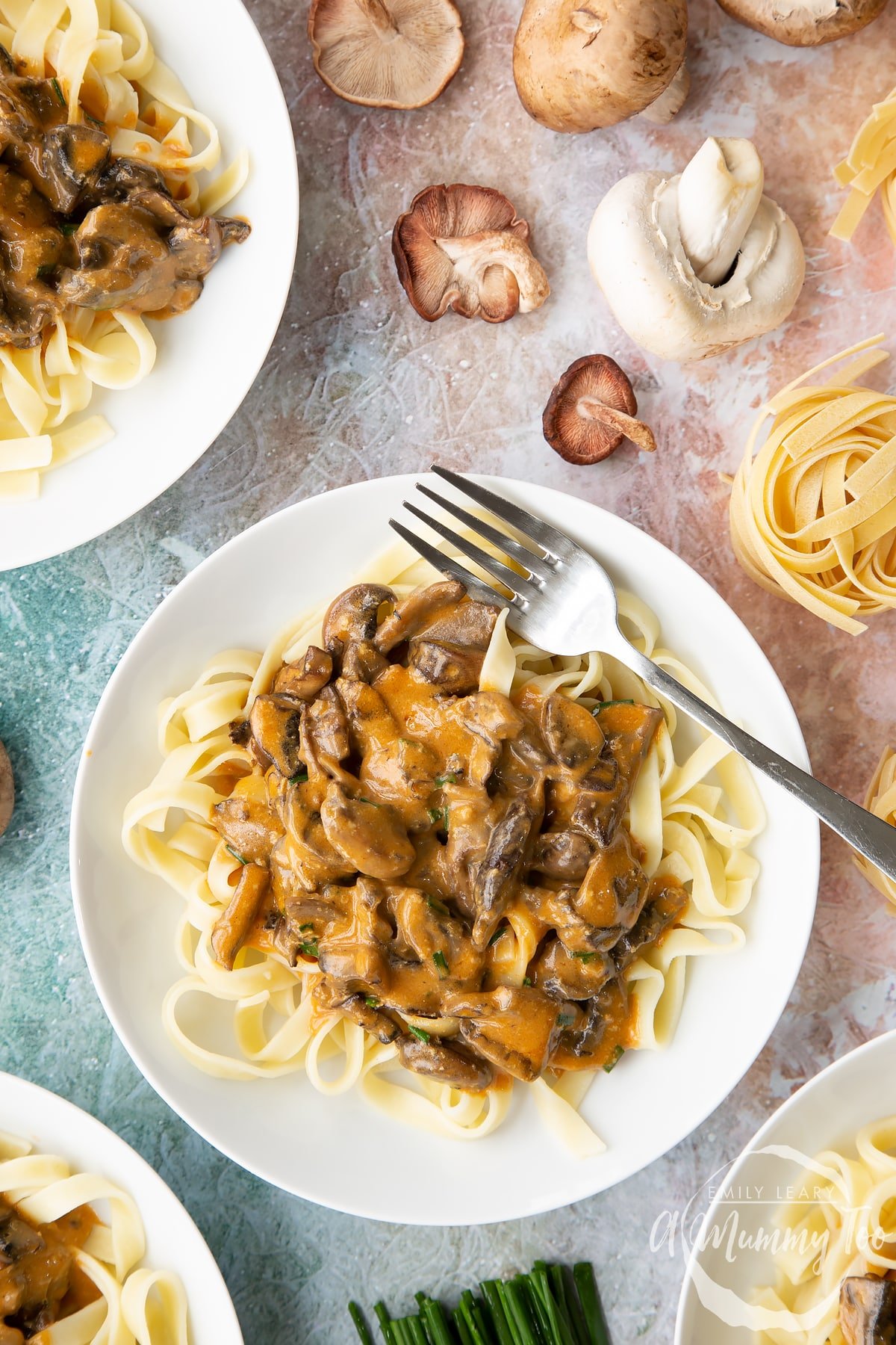 over head view of Creamy vegan mushroom stroganoff on a bed of taglietelle on a white plate.