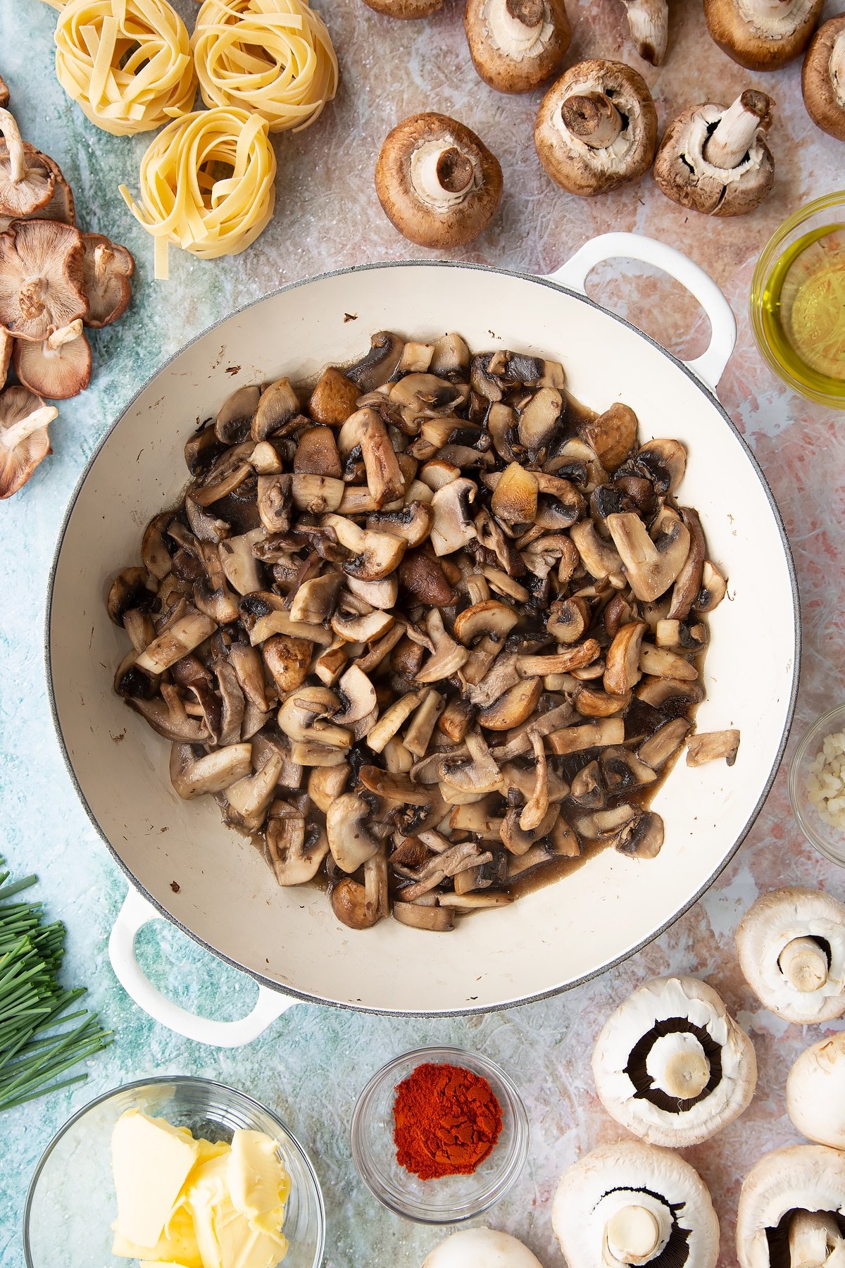 a large white pan with cooked mushrooms in the bottom, with ingredients surrounding the pan.