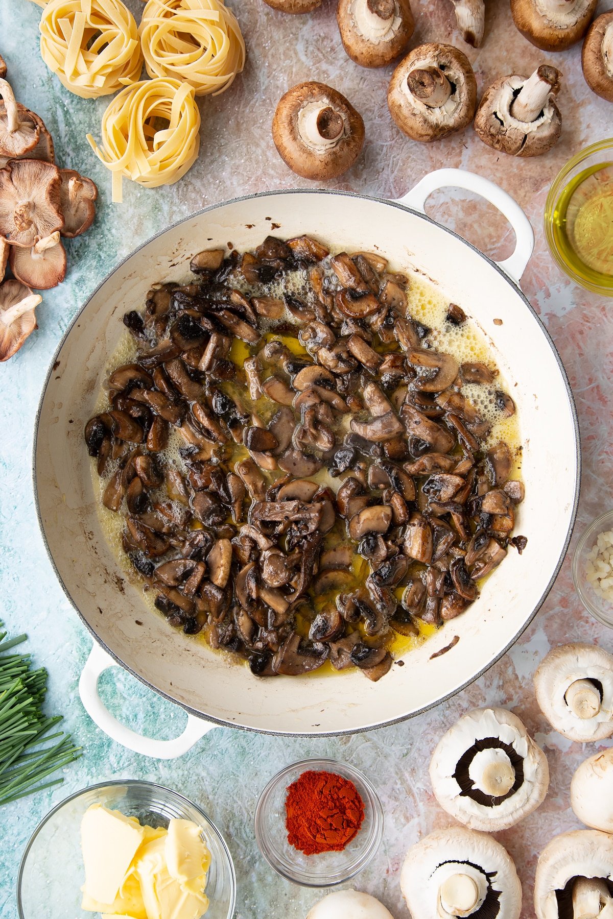 sauteed mushrroms in butter, wine and garlic in a large white pan.