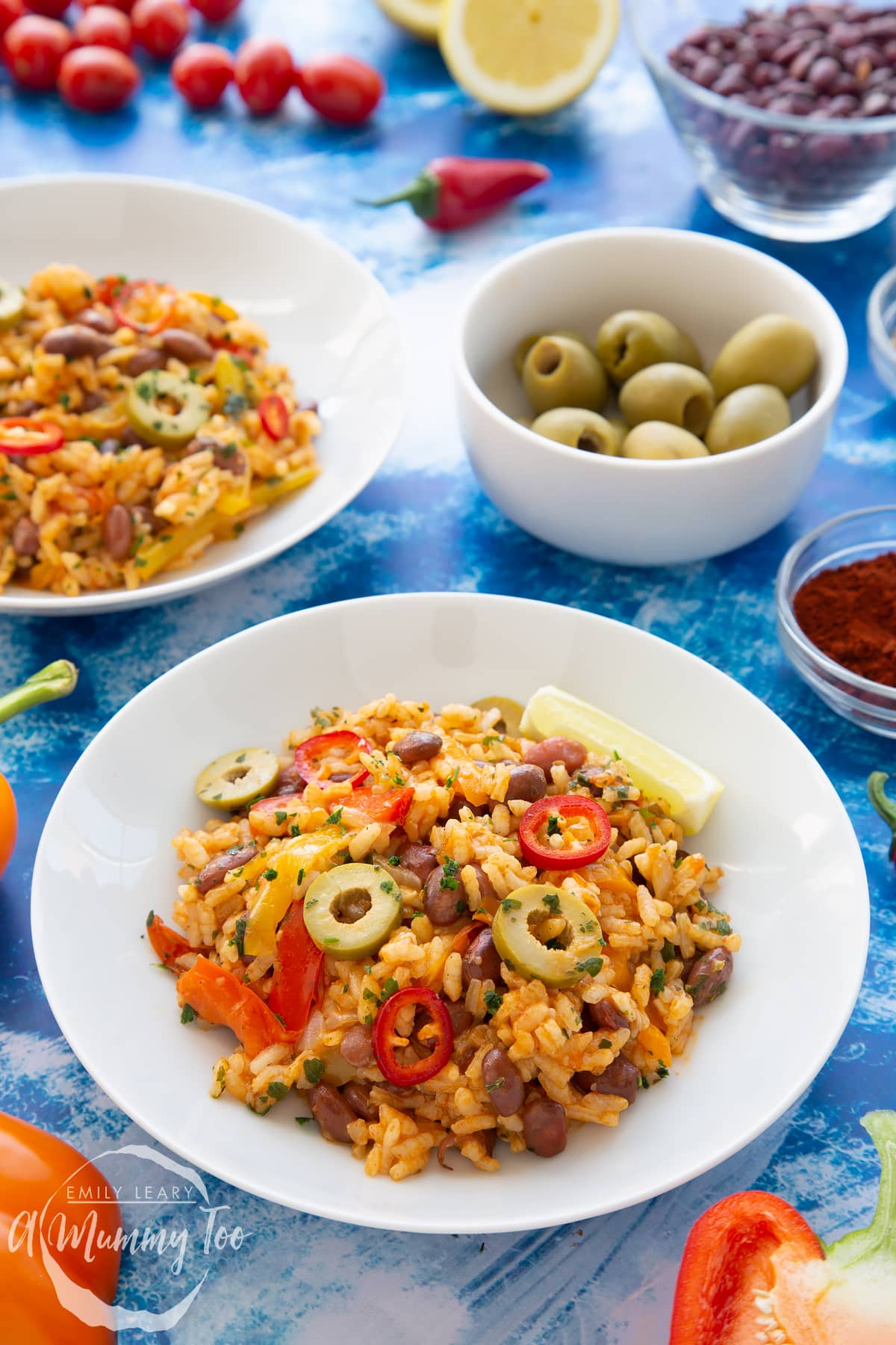 Easy Spanish rice and beans served in a shallow white bowl with a wedge of lime.