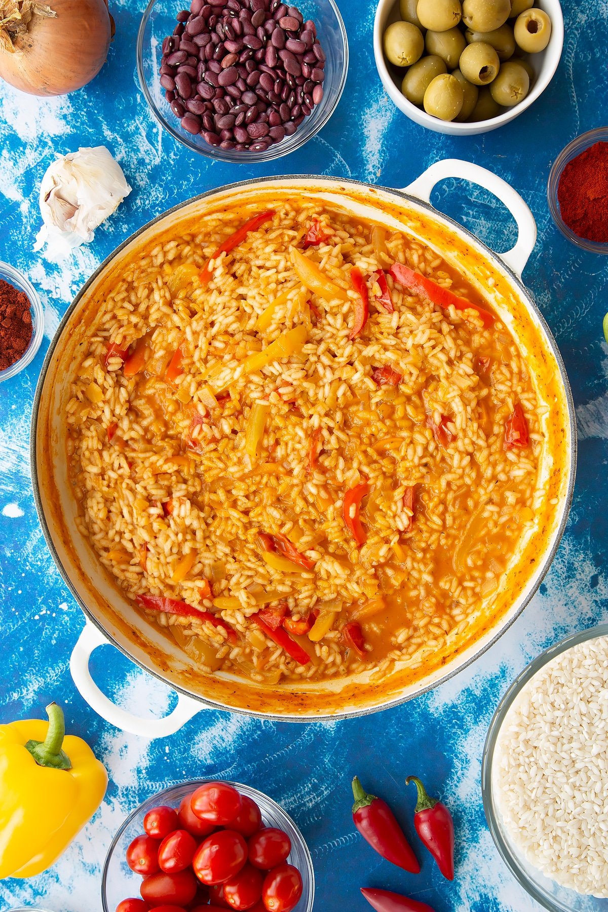 Semi cooked Spanish rice in a large shallow pot.