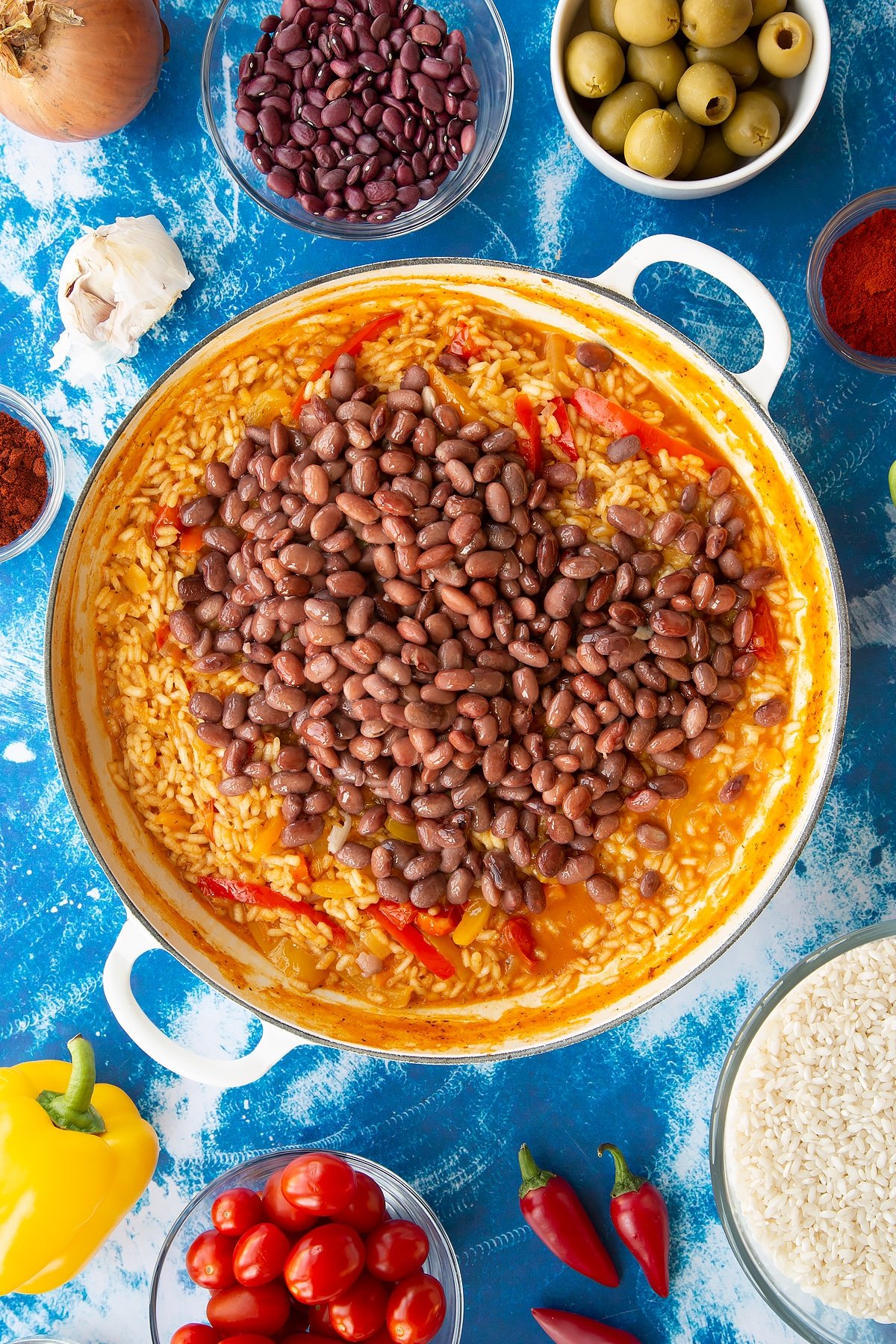 Spanish rice in a large shallow pot with kidney beans on top.