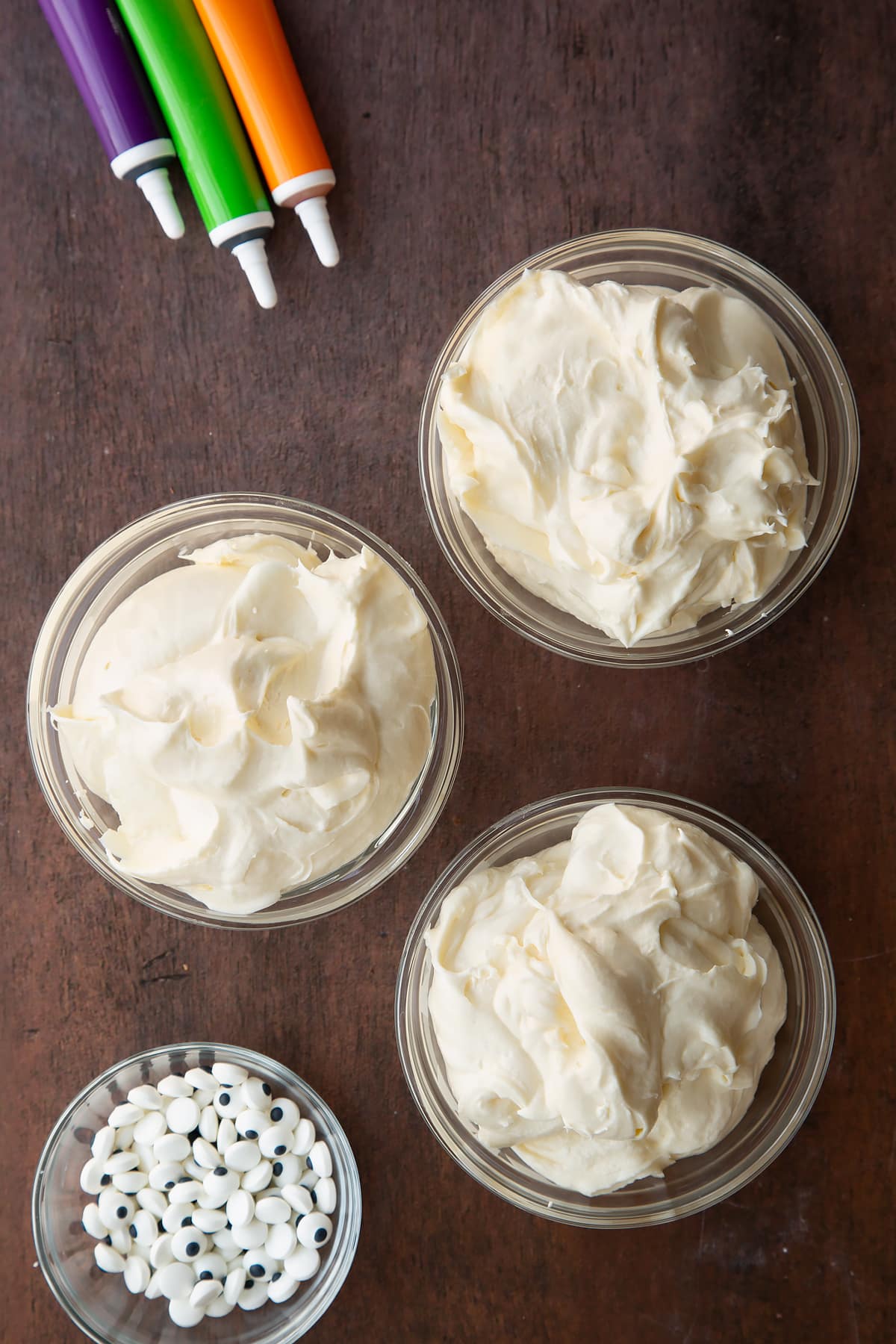 Cream cheese frosting in three glass bowls.