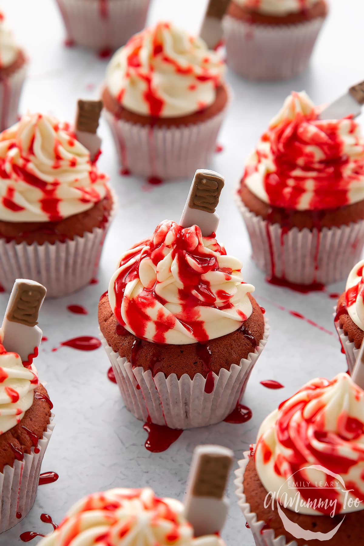 Red velvet Halloween cupcakes, spattered with red syrup. 