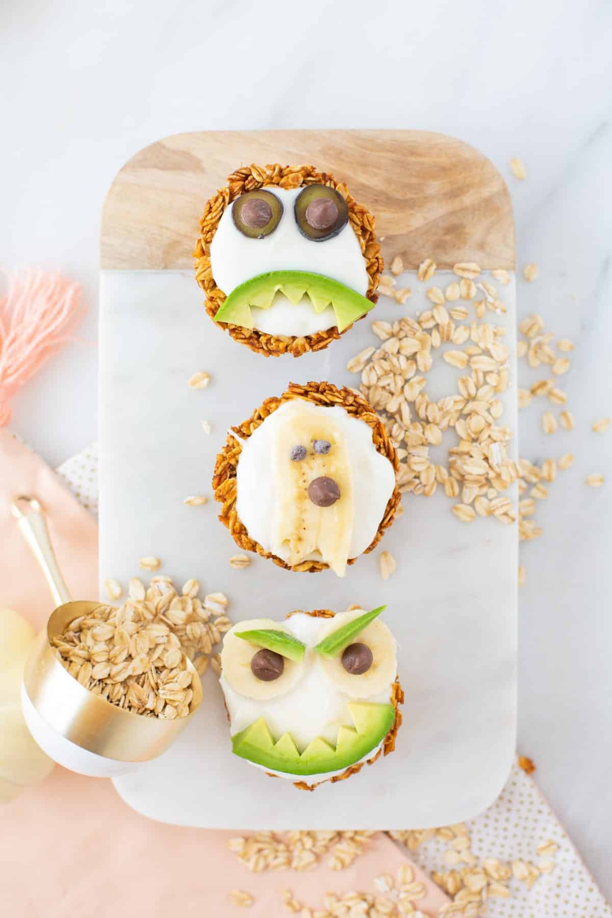 Granola cups filled with yogurt and decorated with fruit pieces to look like monsters.