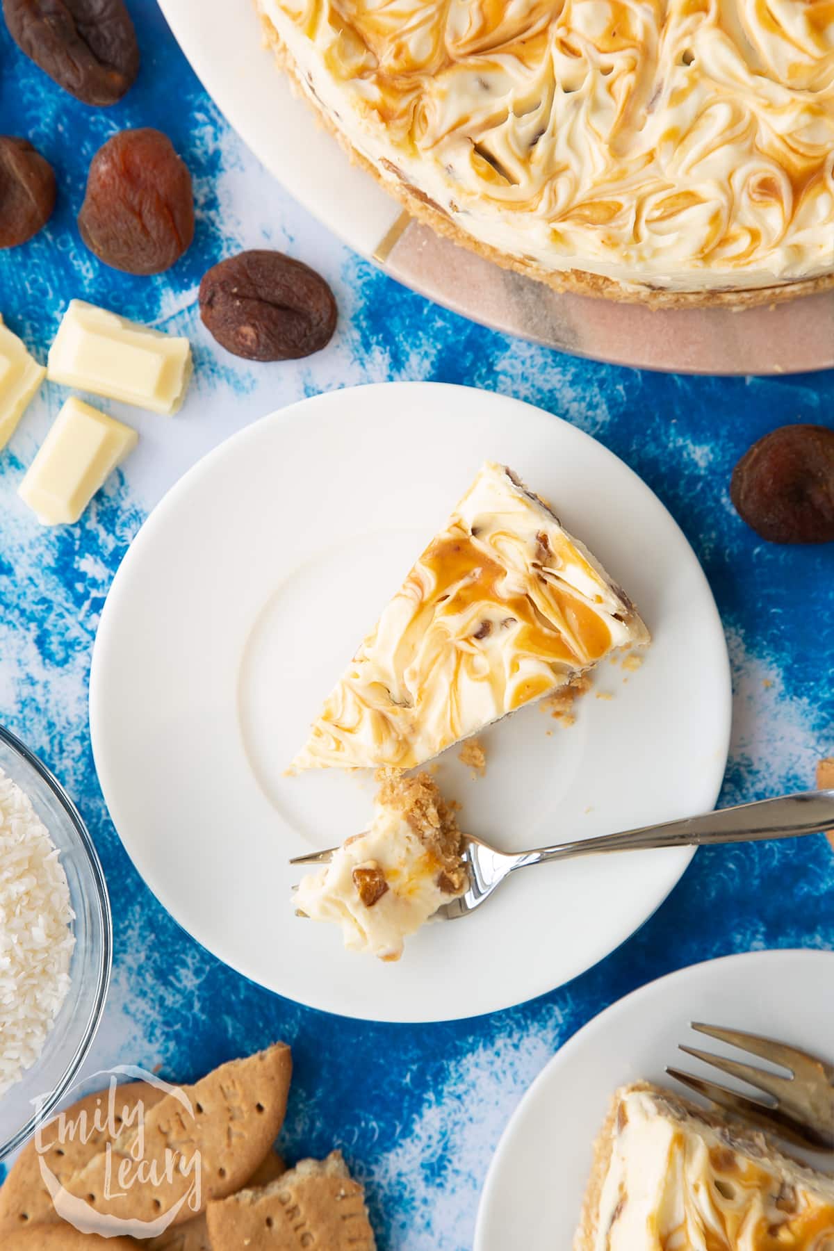 Slice of caramelised apricot cheesecake on a white plate. A fork has taken a piece.