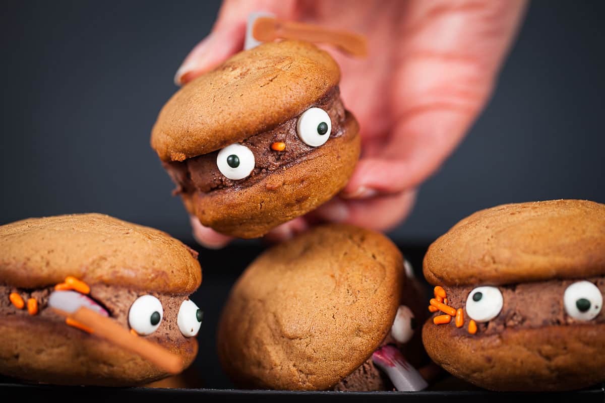 Orange monster sandwich cookies with eyes.