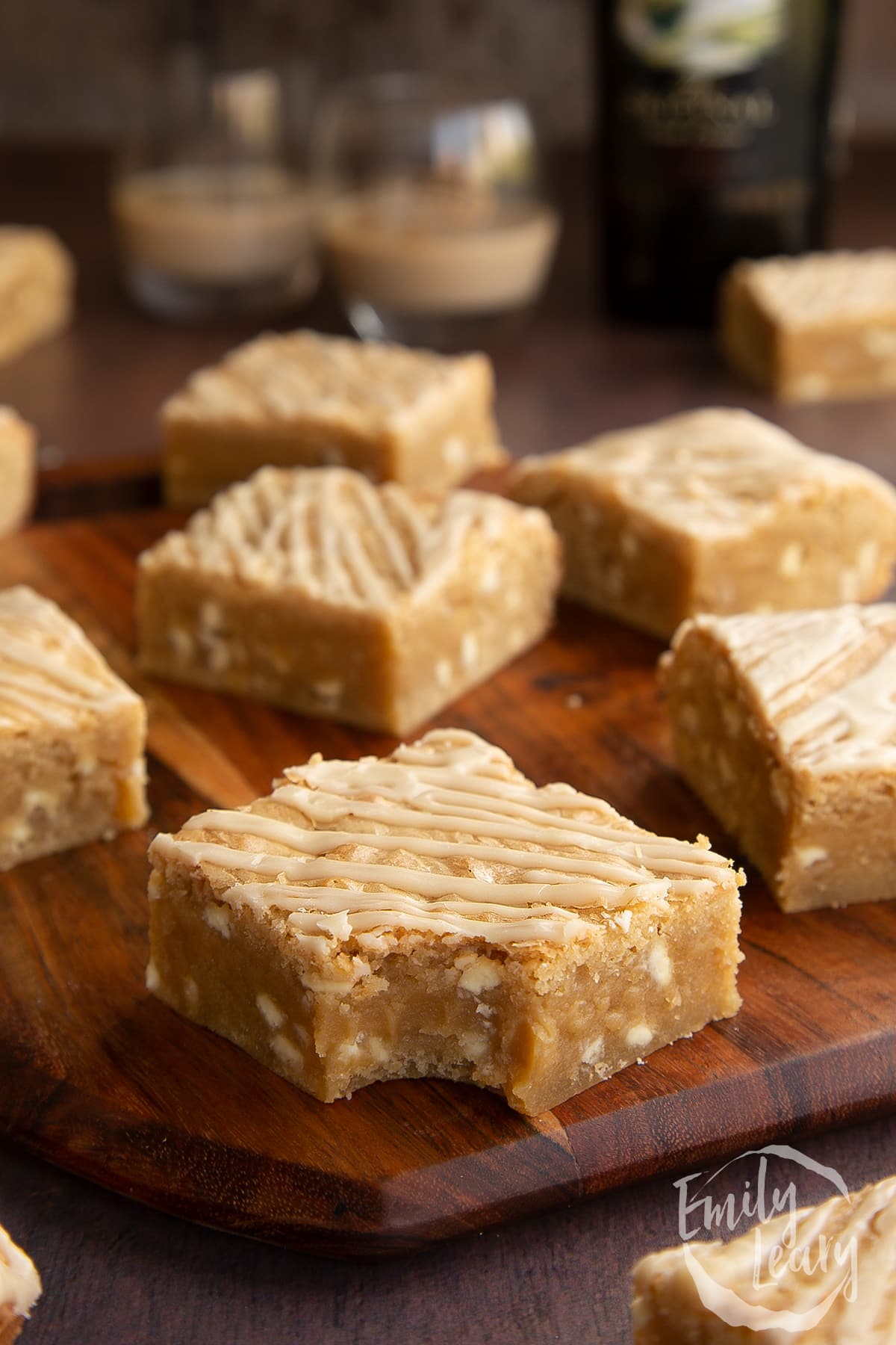 Baileys blondies on a wooden board. One has a bite out of it.