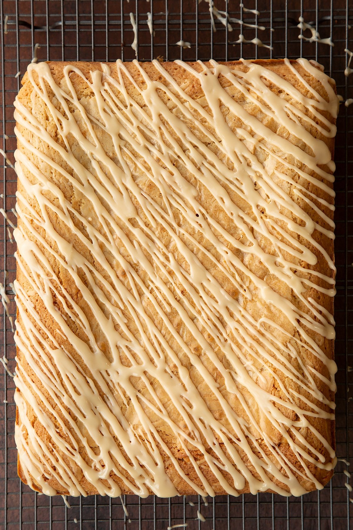 Freshly baked Baileys blondie drizzled with Baileys icing on a wire rack.