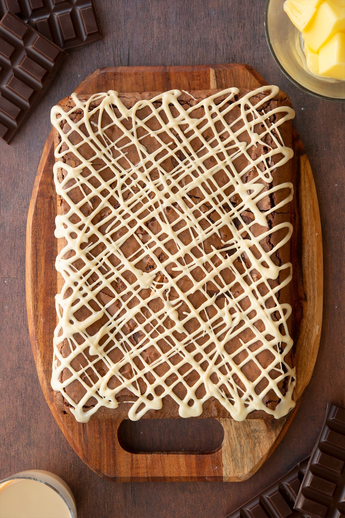 Freshly baked Baileys brownie on a board. It has been drizzled with Baileys 