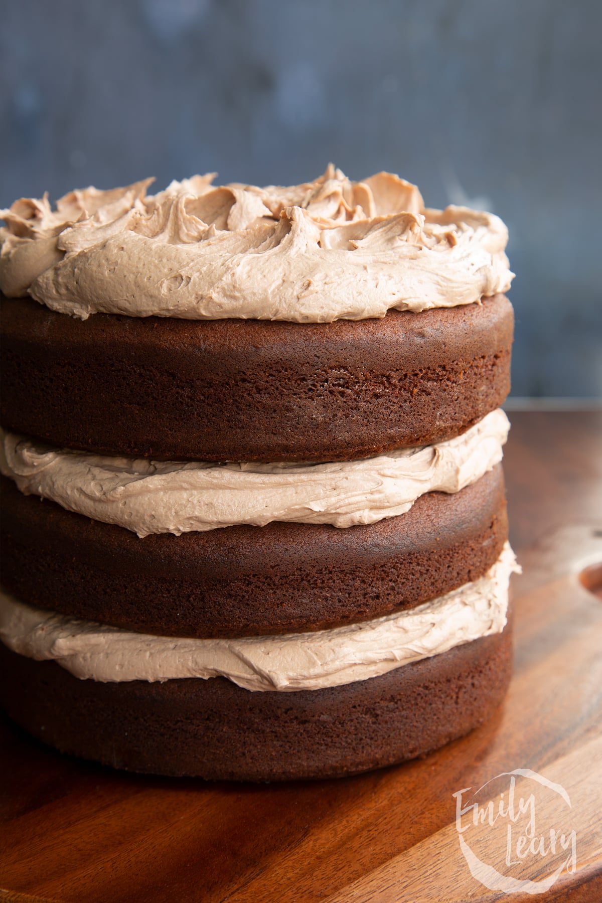 Close up of three tier chocolate Baileys cake, sandwiched and topped with Baileys buttercream frosting.