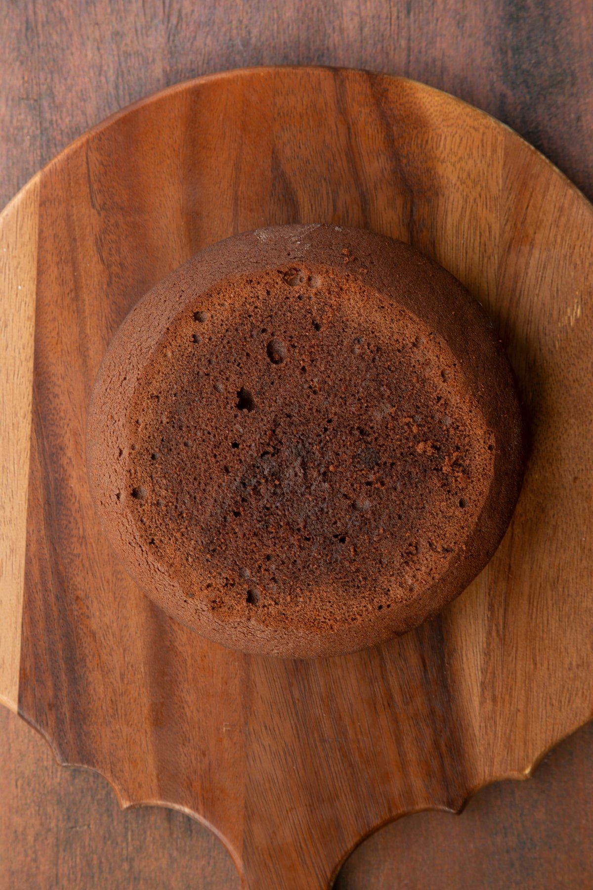 A layer of Baileys chocolate cake on a wooden board.