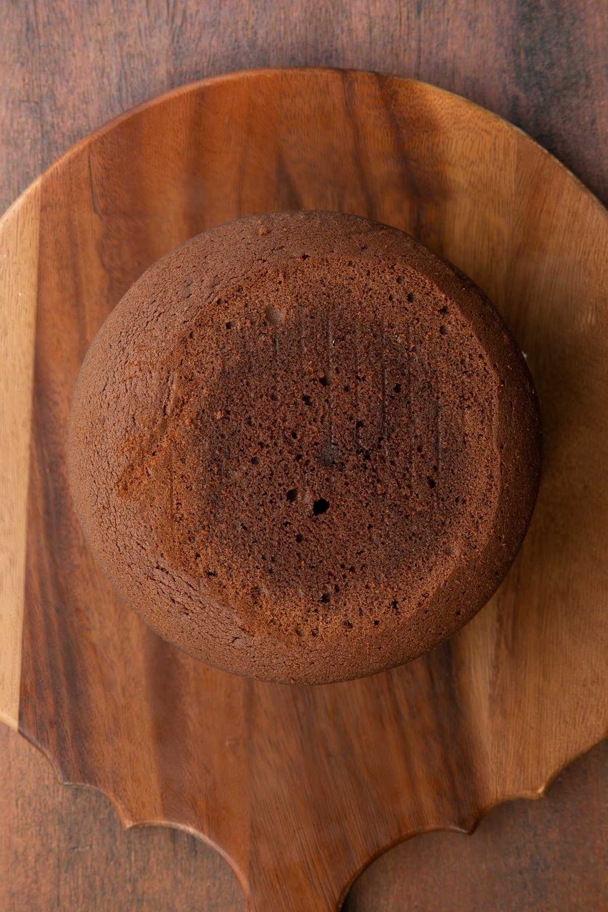 Two layers of Baileys chocolate cake, sandwiched with Baileys icing on a wooden board.