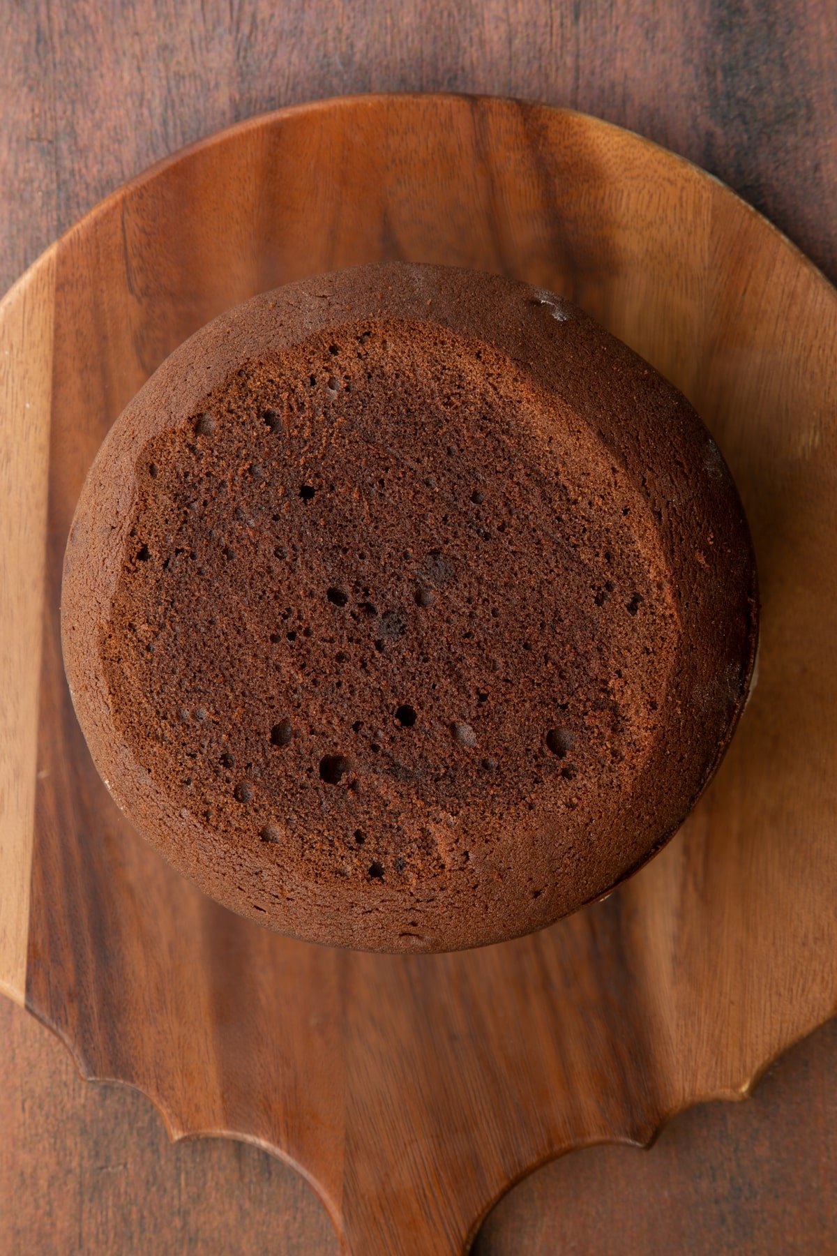 Three layers of Baileys chocolate cake, sandwiched with Baileys icing on a wooden board.