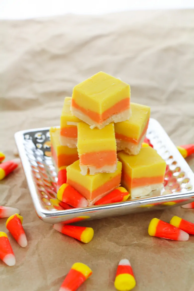 A plate of yellow orange and white candy corn fudge.
