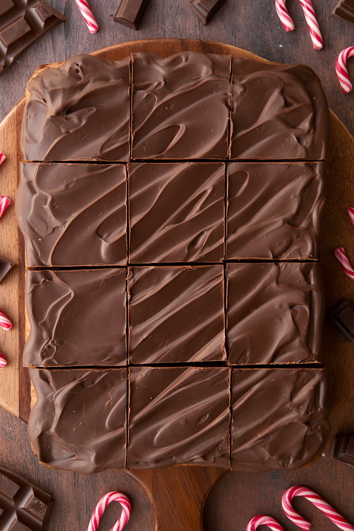 Candy cane brownies on a board, cut into 12 pieces.