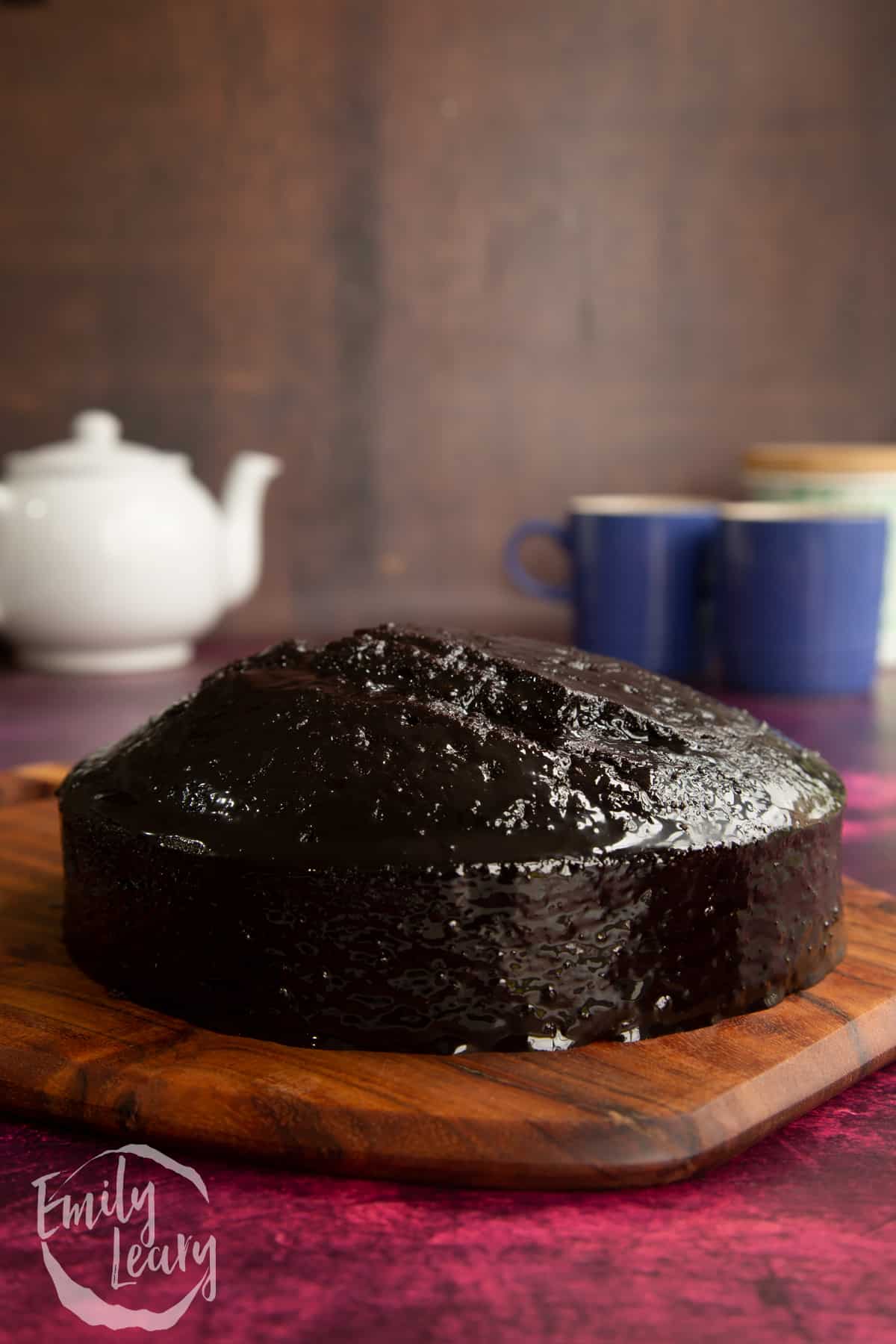 Chocolate drizzle cake on a wooden board.