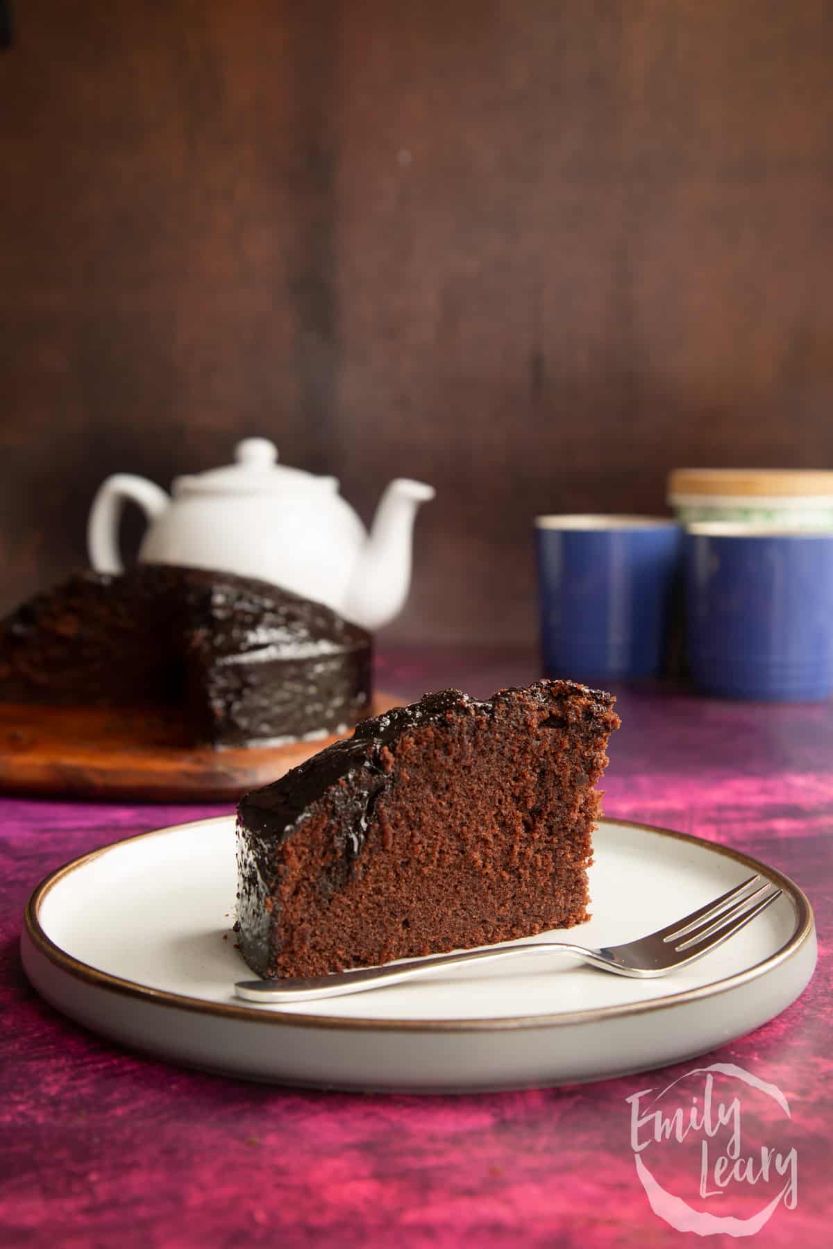 A slice of chocolate drizzle cake on a plate.