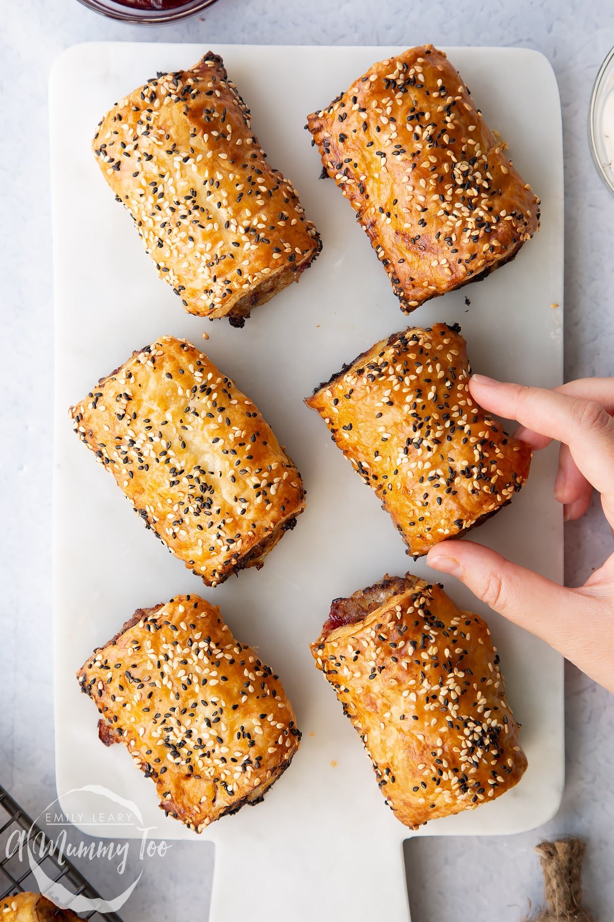 Festive sausage rolls on a white marble board.