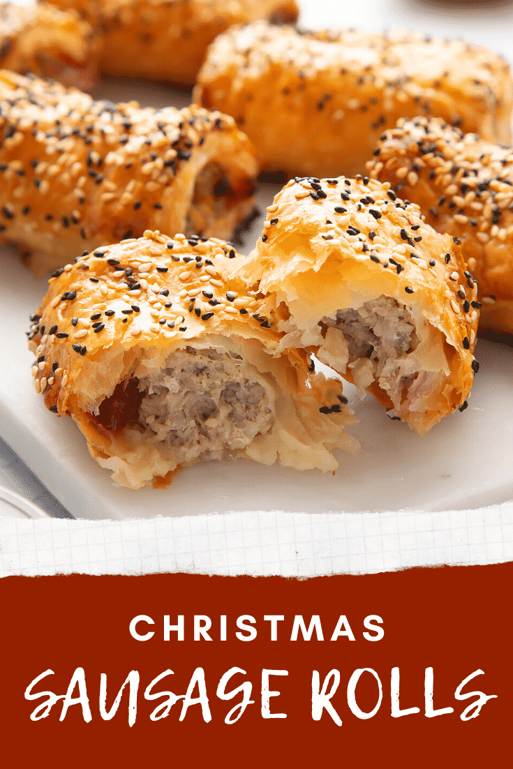 A festive sausage roll broken open on a white marble board. Caption reads: Christmas sausage rolls