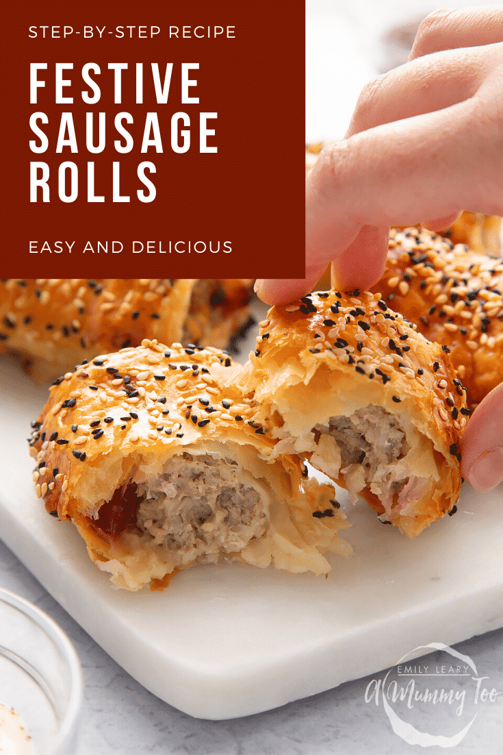 A festive sausage roll broken open on a white marble board. A hand reaches for it. Caption reads: Step-by-step recipe. Christmas sausage rolls. Easy and delicious.