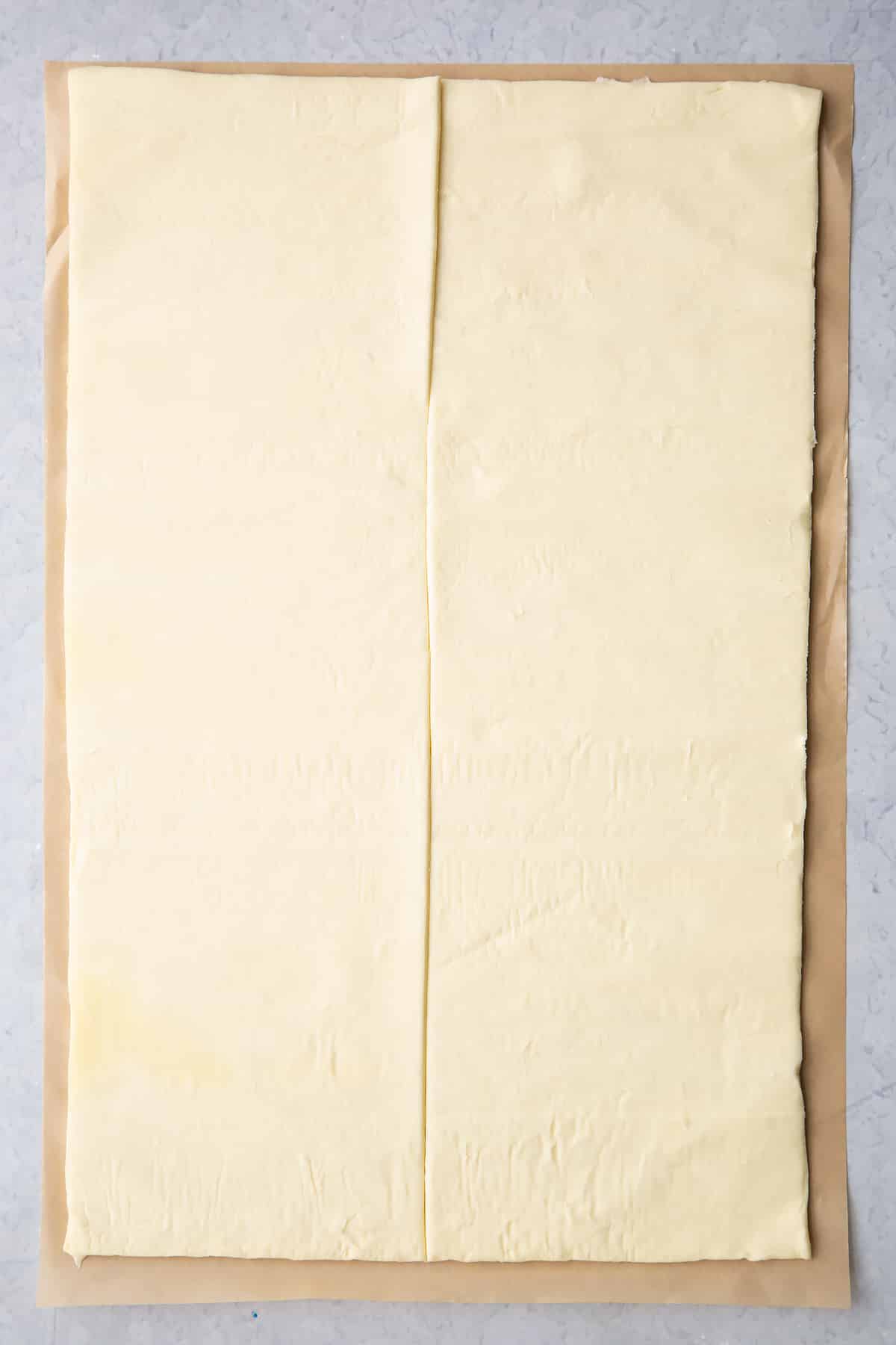 A sheet of puff pastry cut in half lengthways.