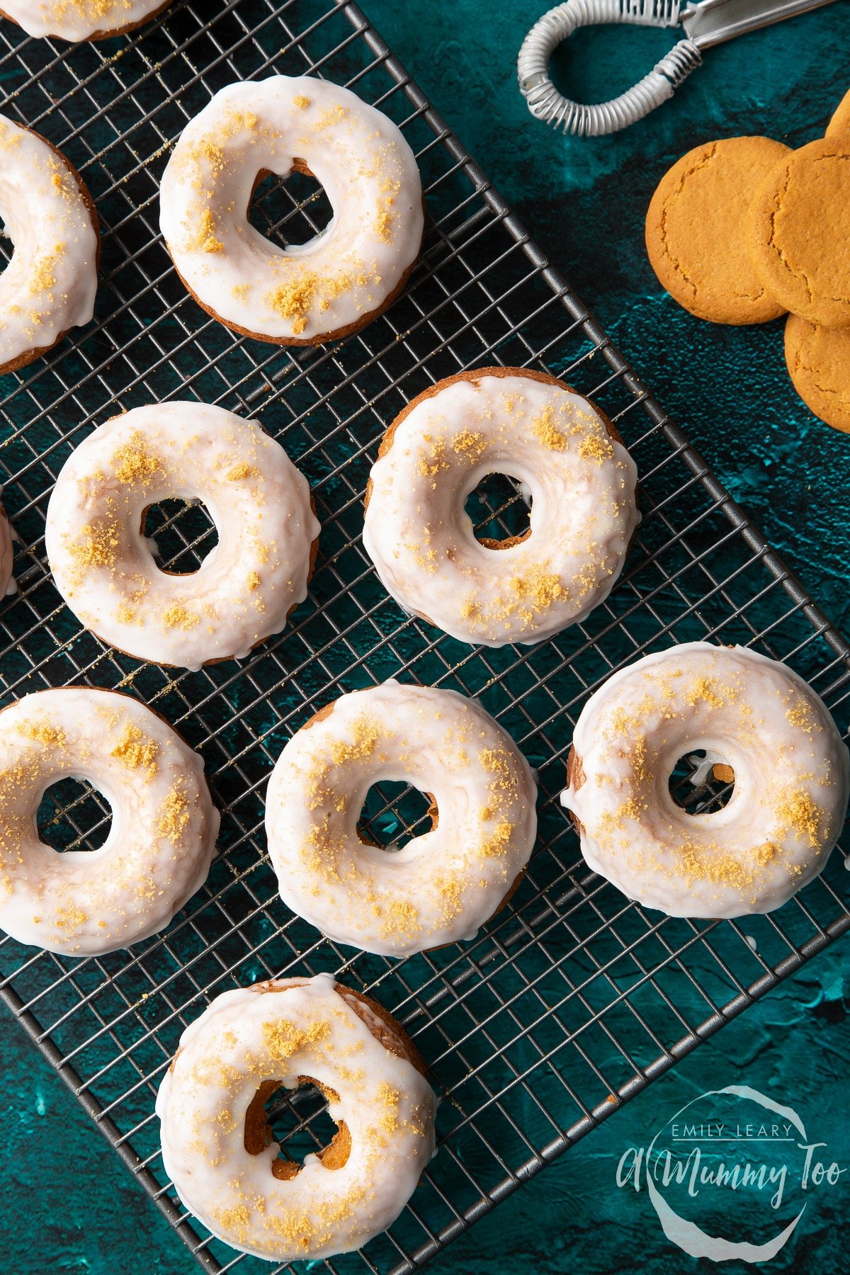 Baked gingerbread donuts with a lemon glaze on a wire cooling rack. Shown from above. 