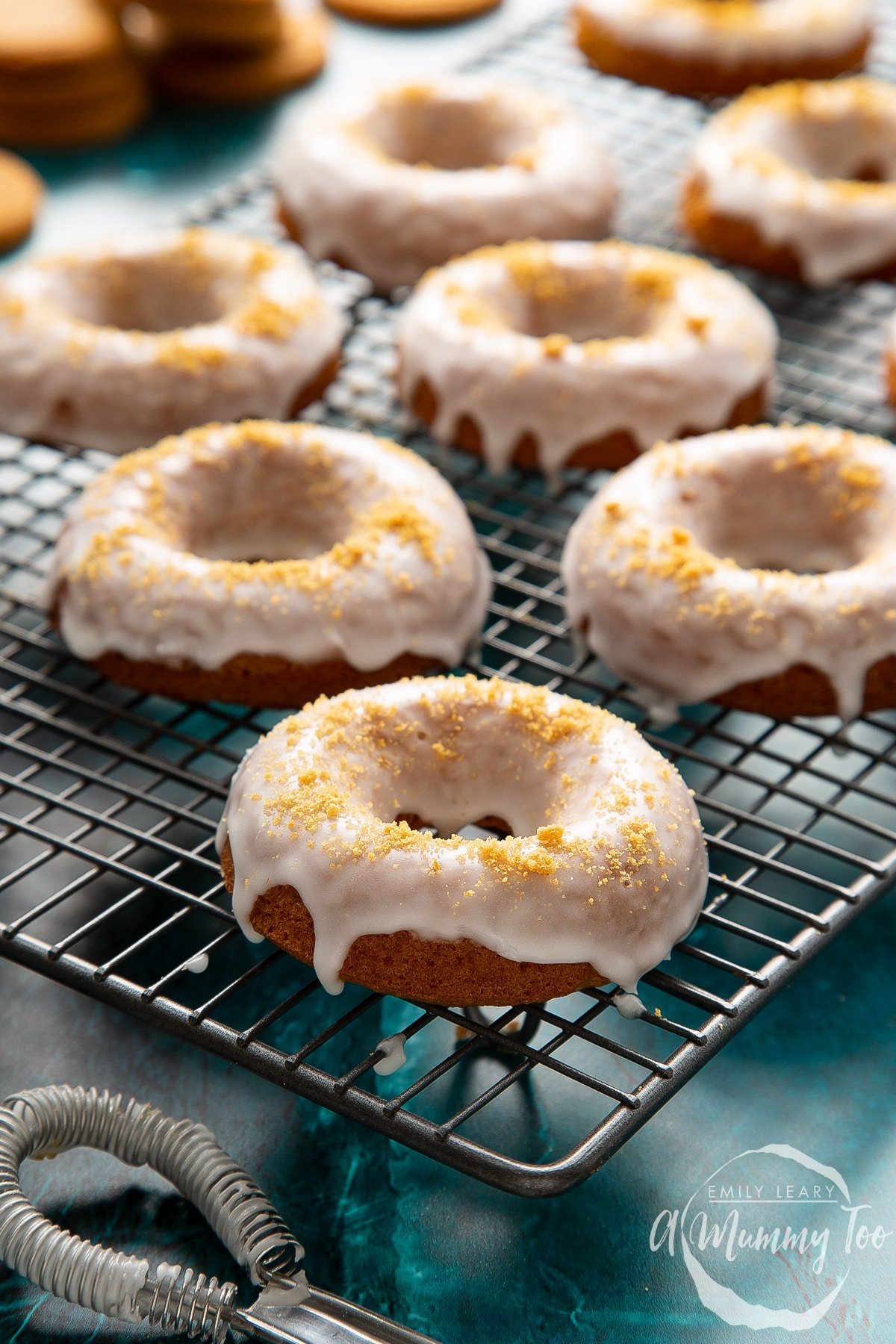 Baked gingerbread donuts, dipped in a lemon glaze on a wire cooling rack. 