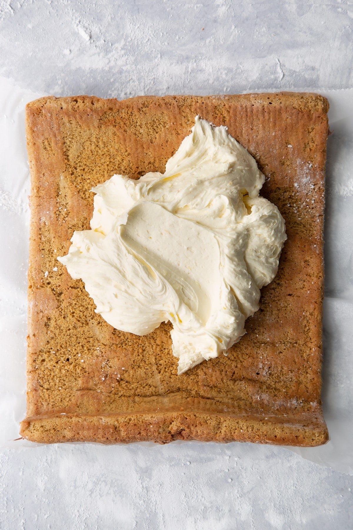 Gingerbread Swiss roll sponge unrolled and topped with lemon white chocolate buttercream.