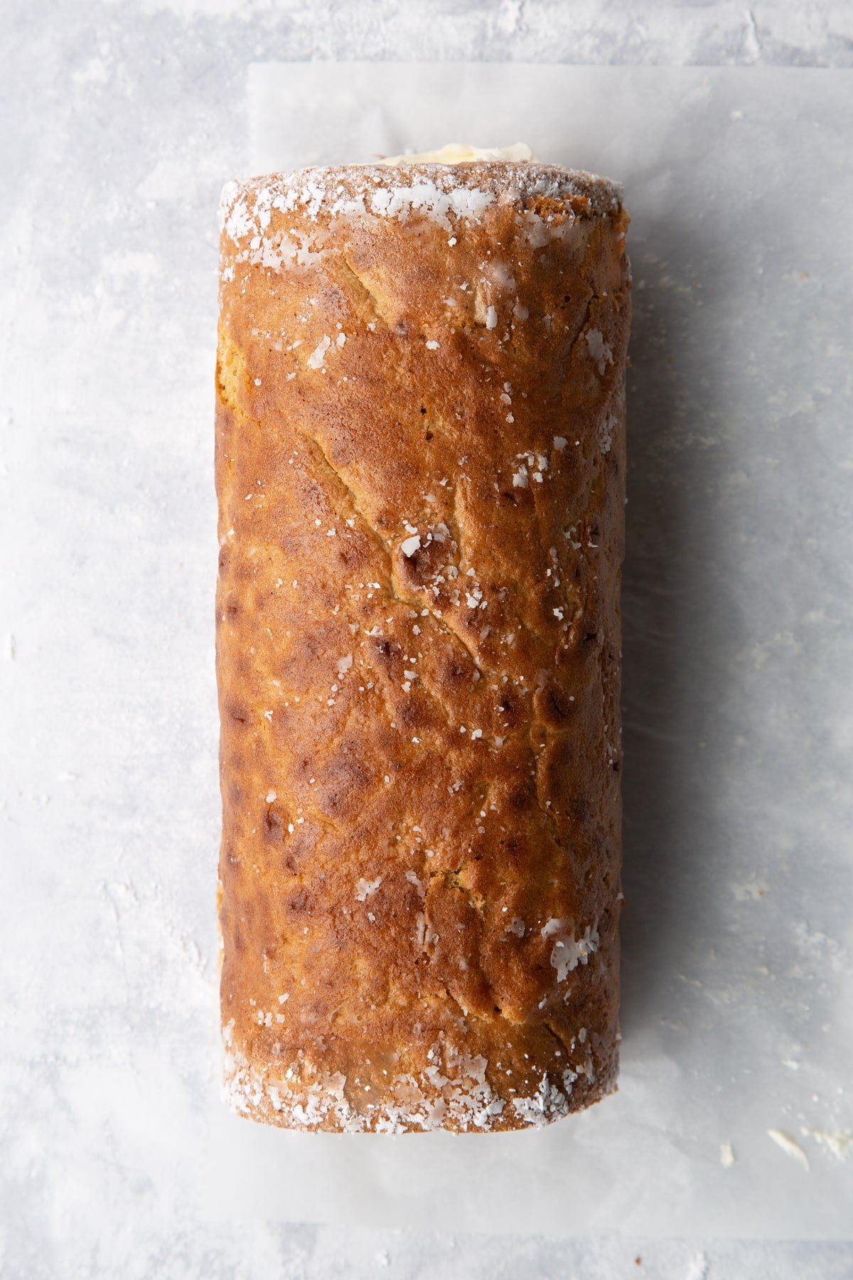 Gingerbread Swiss roll on an icing sugar dusted surface.