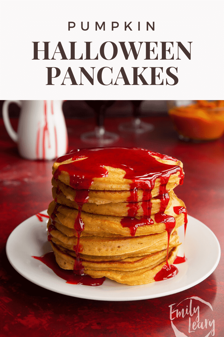 Halloween pancakes stacked on a white plate, drizzled with red syrup. Caption reads: Pumpkin Halloween pancakes. 