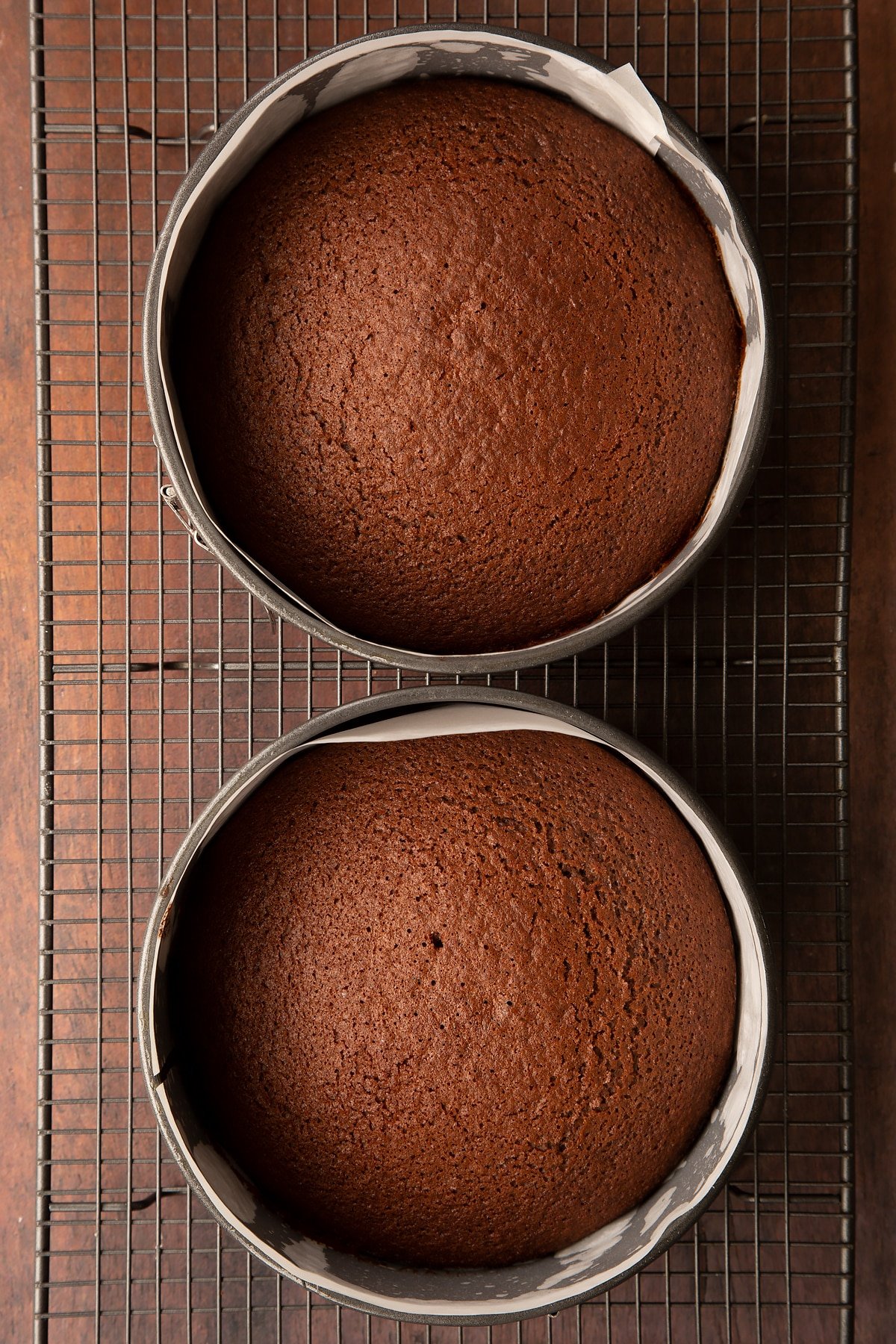 Chocolate cakes in a two lined baking tins on a wire rack.