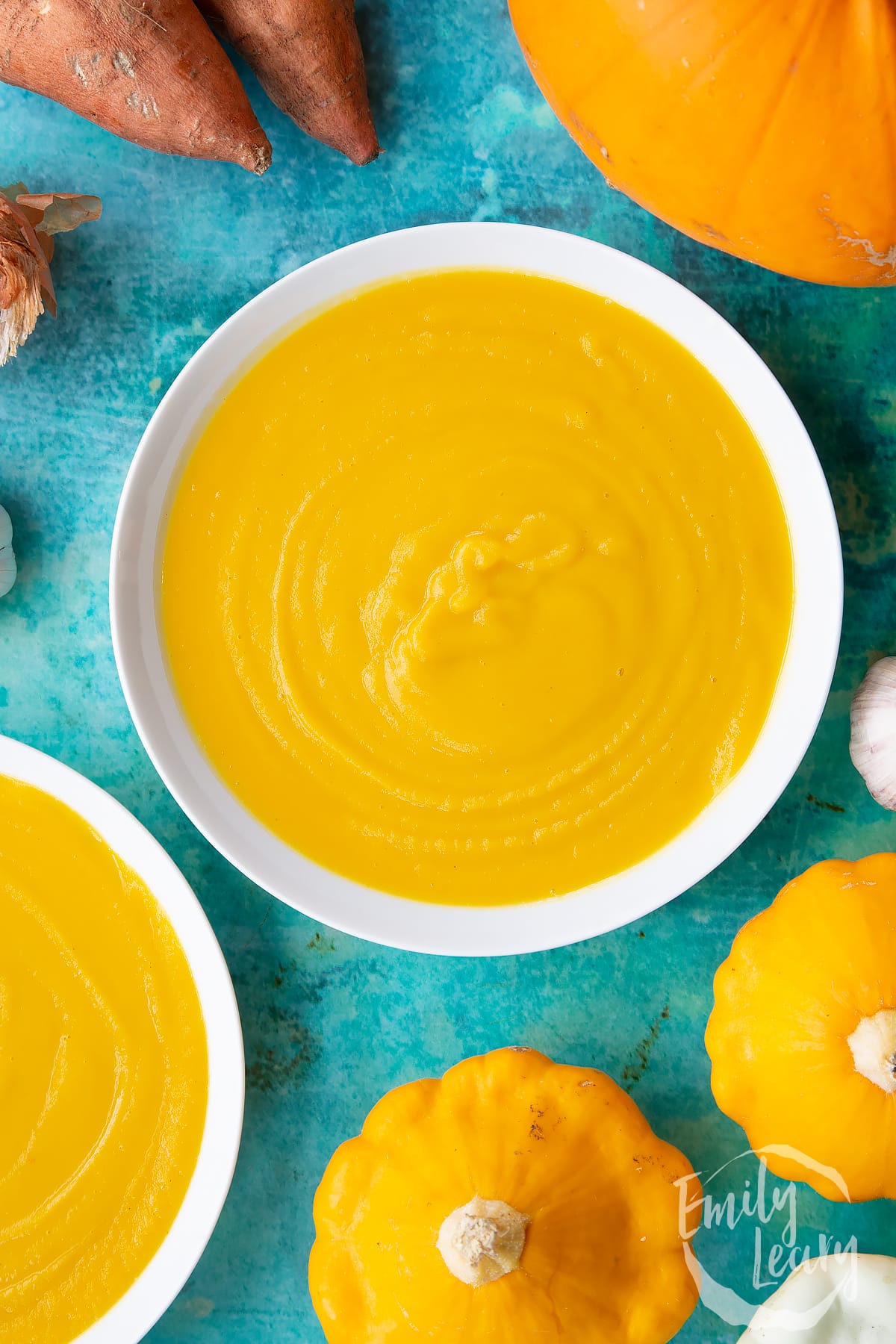 Pumpkin and sweet potato soup in a white bowl, from above. 