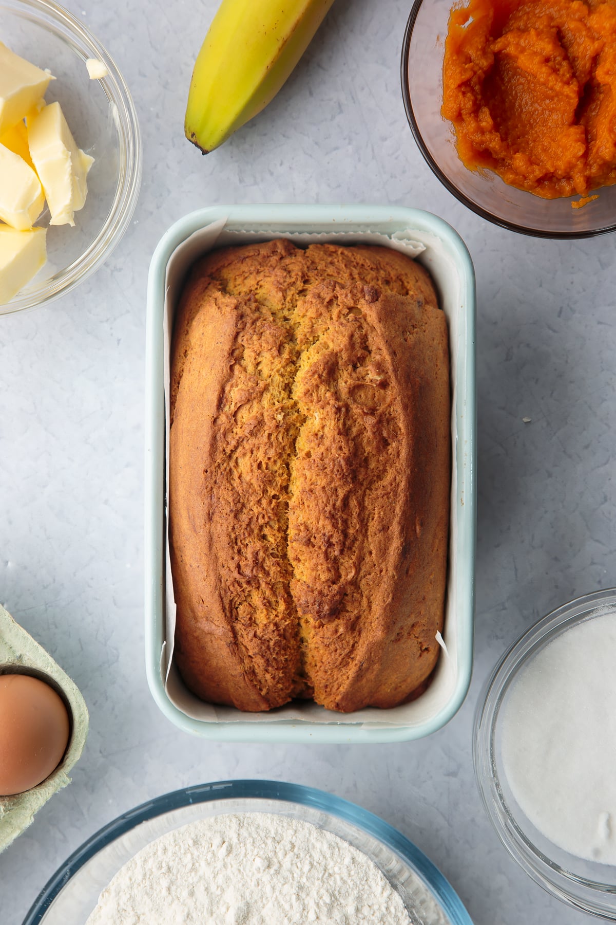 Freshly baked pumpkin banana bread loaf in a lined loaf tin.