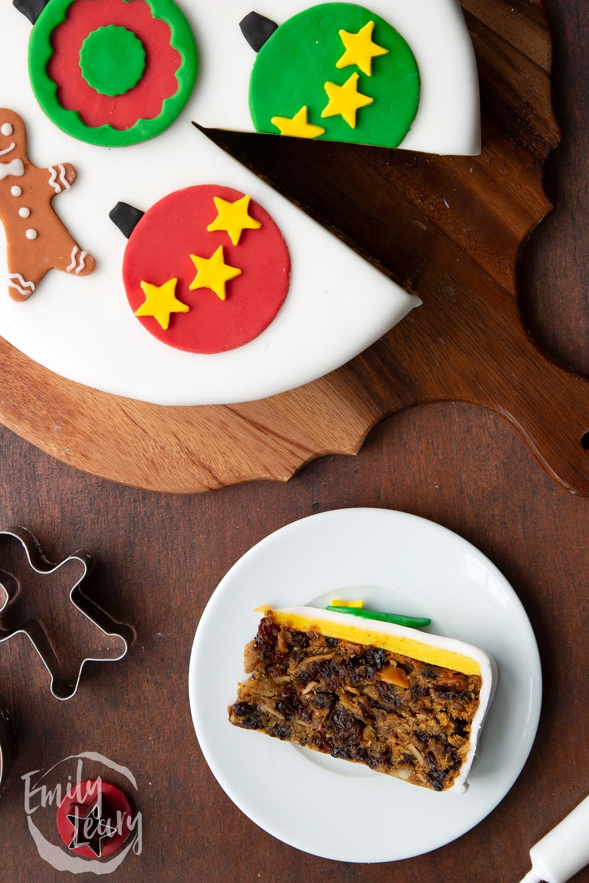 Slice of vegan Christmas cake laying on its side on a white plate. Shown from above.