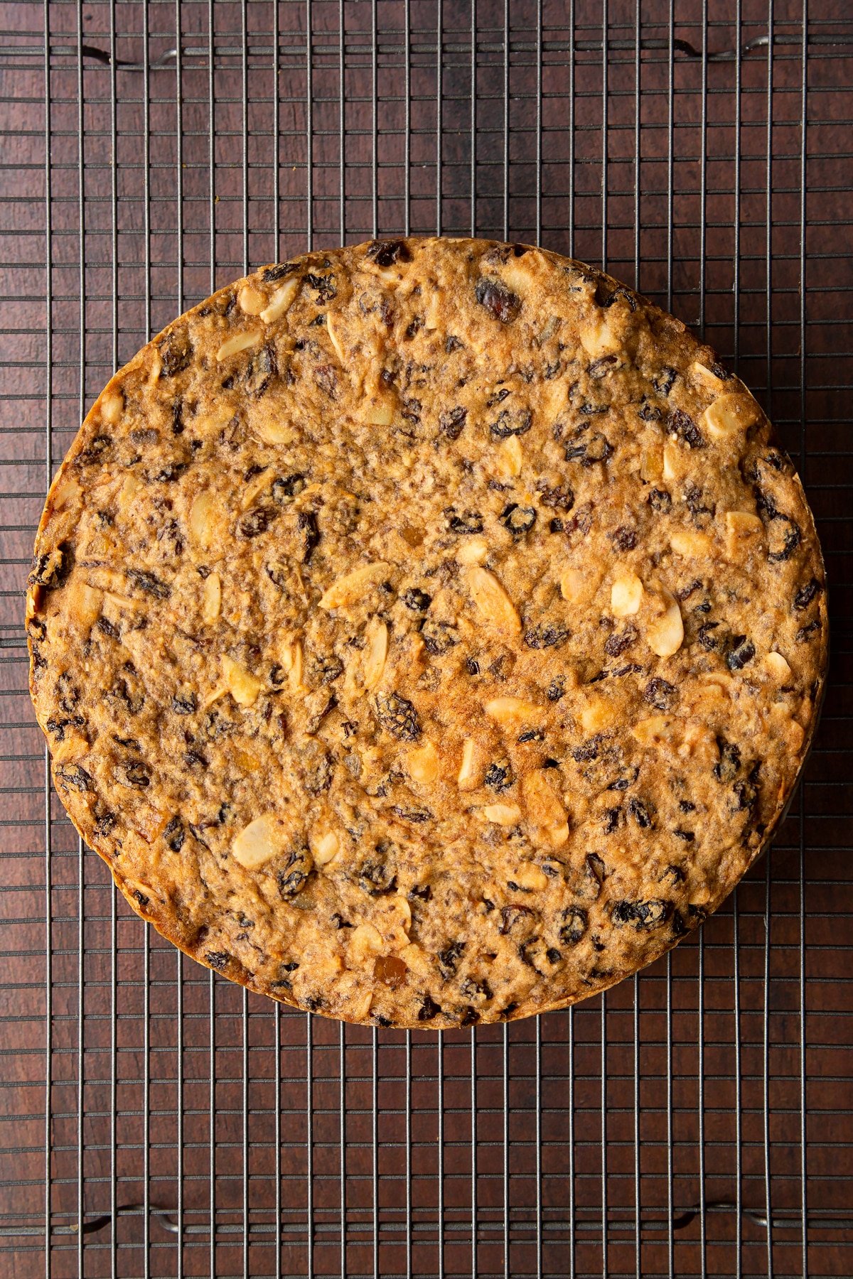 Freshly baked vegan Christmas cake on a wire cooling rack.