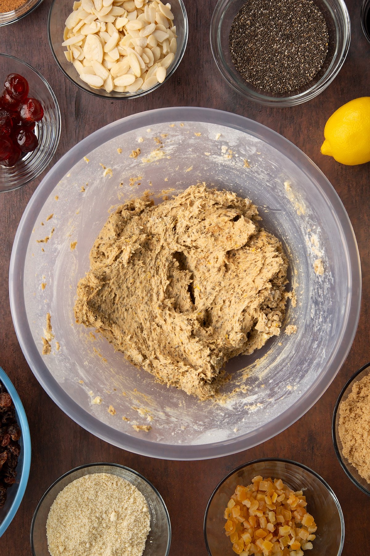 Vegan butter, brown sugar, chia "egg", black treacle, Add the flour, ground almonds, mixed spice, nutmeg, orange zest and lemon zest, whisked together in a large plastic bowl. Ingredients to make vegan Christmas cake surround the bowl.