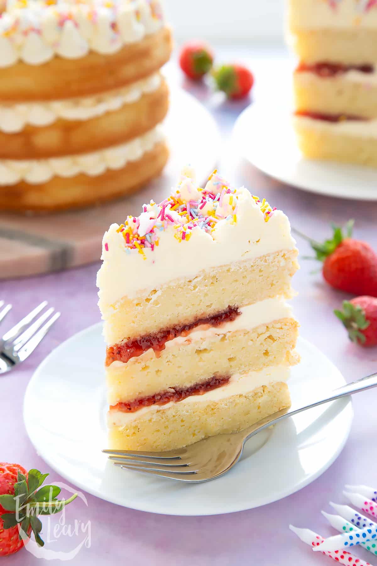 Slice of vegan birthday cake on a small white plate with a fork.