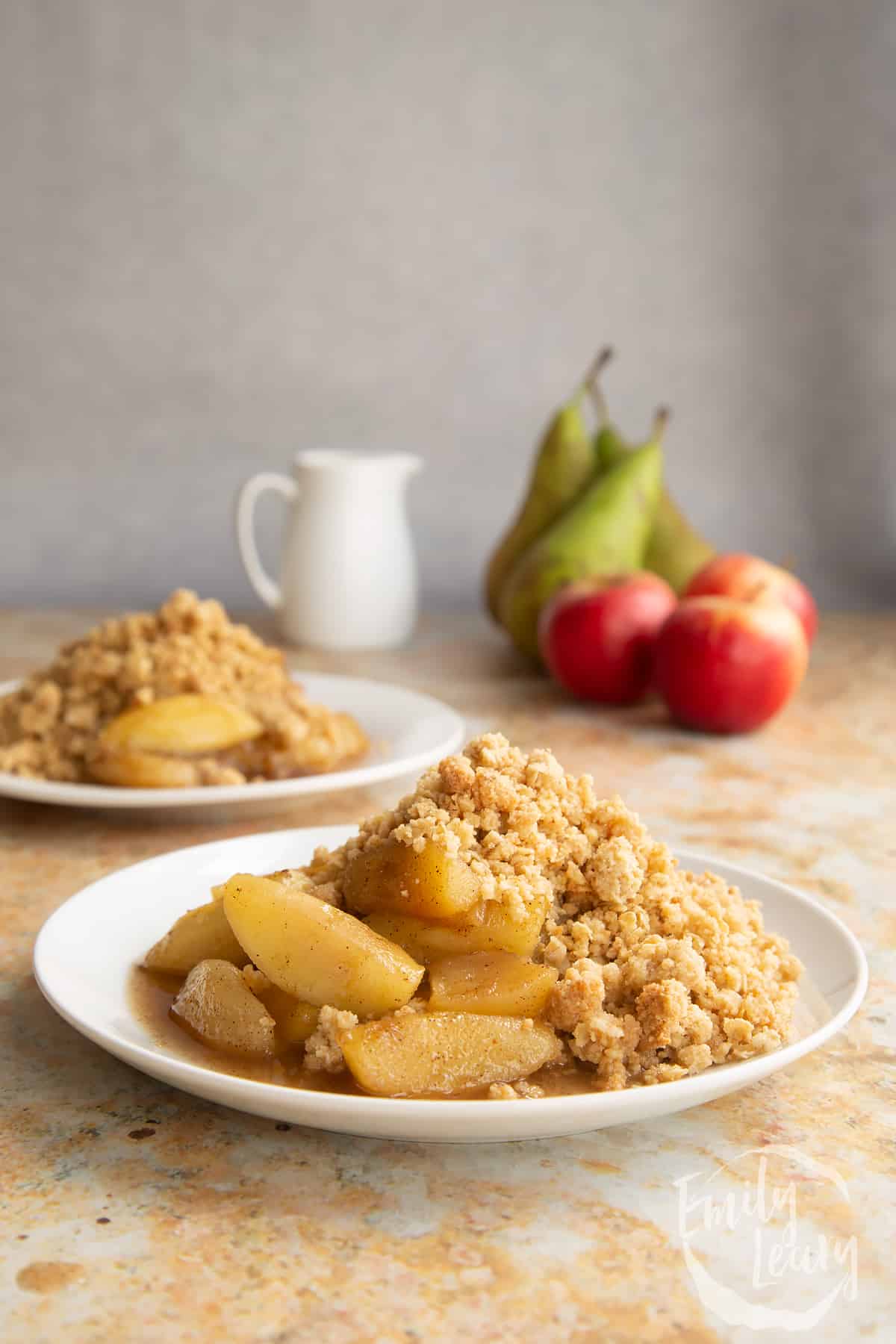 Apple pear crumble served to a small white plate.