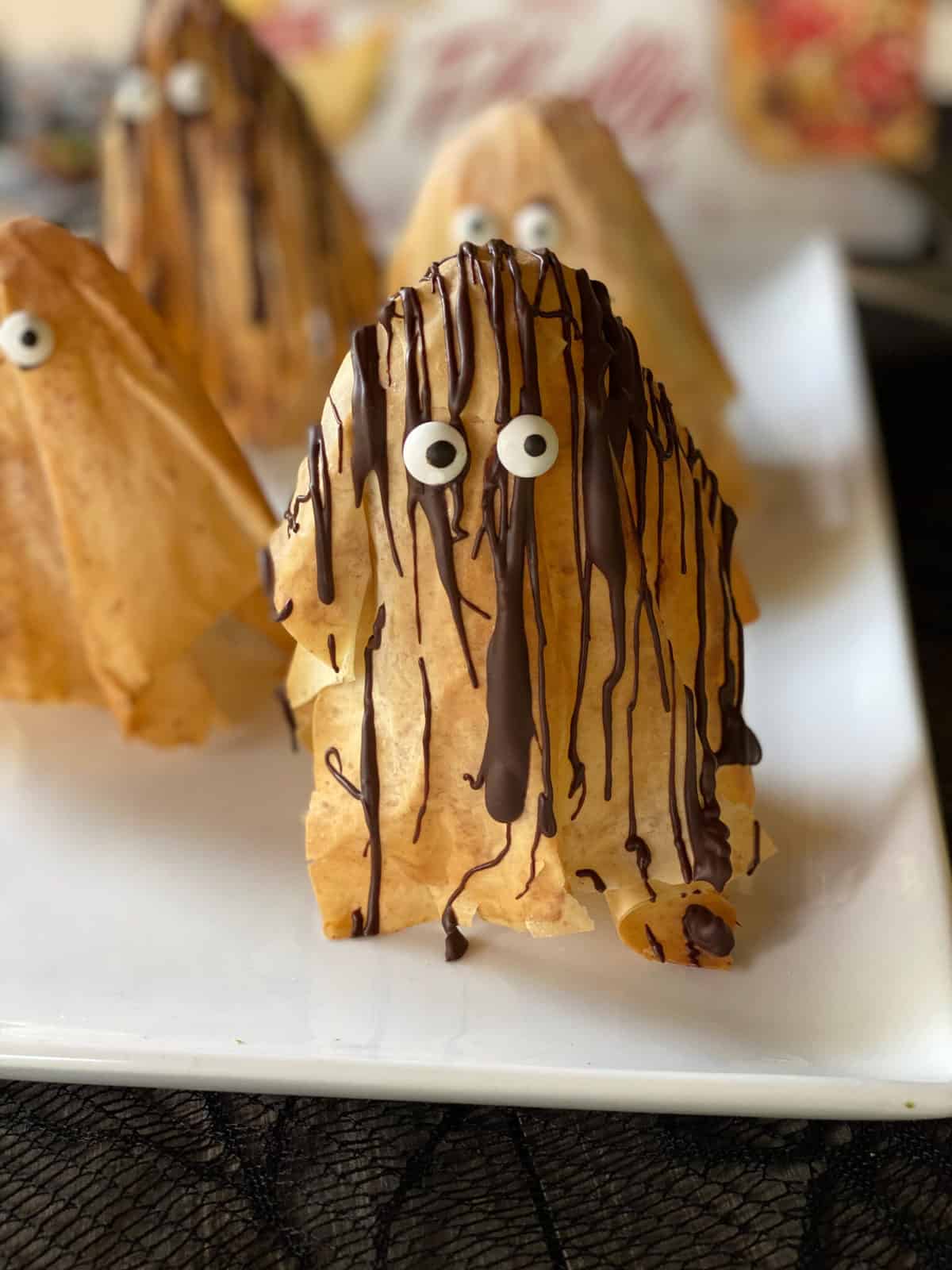 Phyllo pastry ghosts drizzled with chocolate.