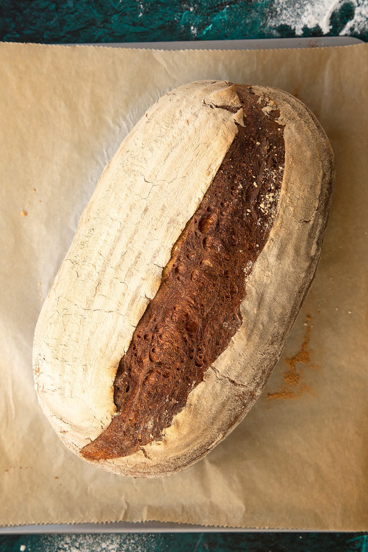 Freshly baked pumpkin sourdough bread on a baking sheet lined with baking paper.