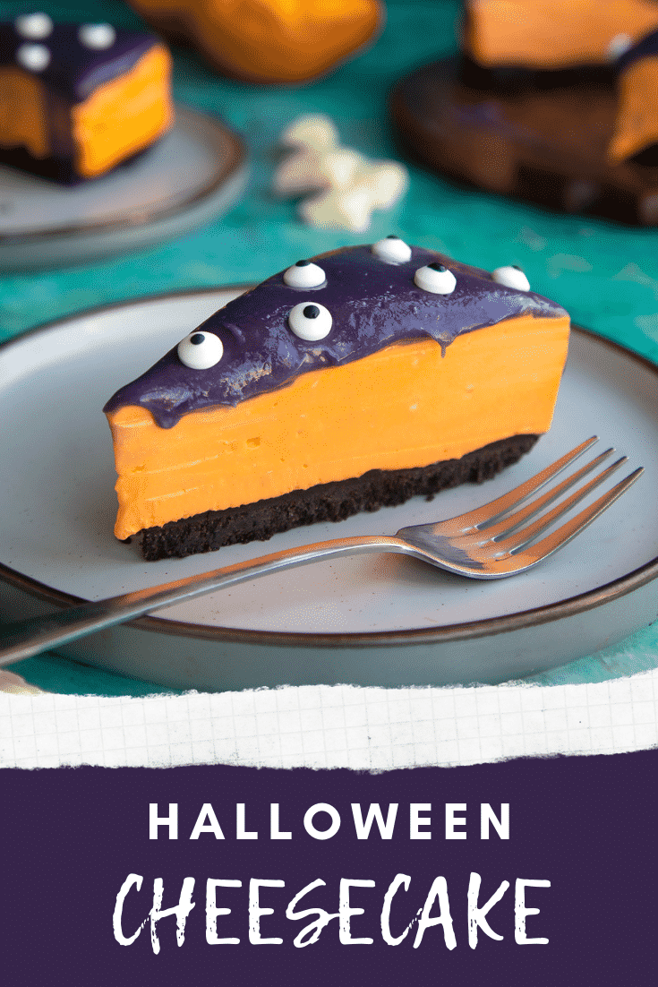 Slice of orange and strawberry Halloween cheesecake with an Oreo base on a plate with a fork. Caption reads: Halloween cheesecake.