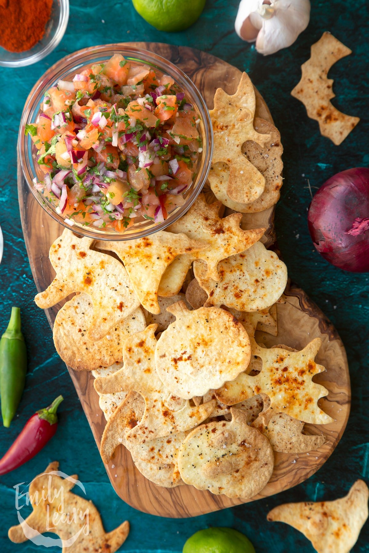 Halloween tortillas on a board with a small bowl of tomato salsa.