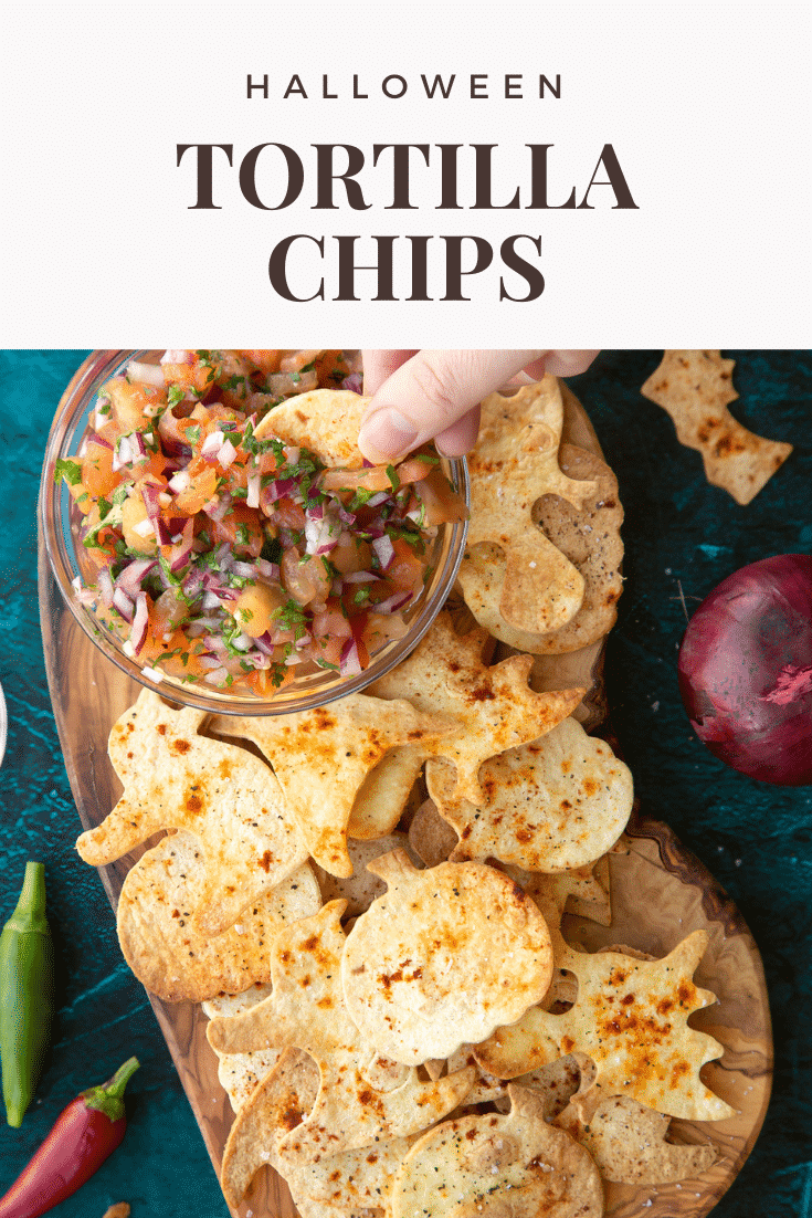 Halloween tortillas on a board with a small bowl of tomato salsa. A hand dips half a chip. Caption: Halloween tortilla chips.
