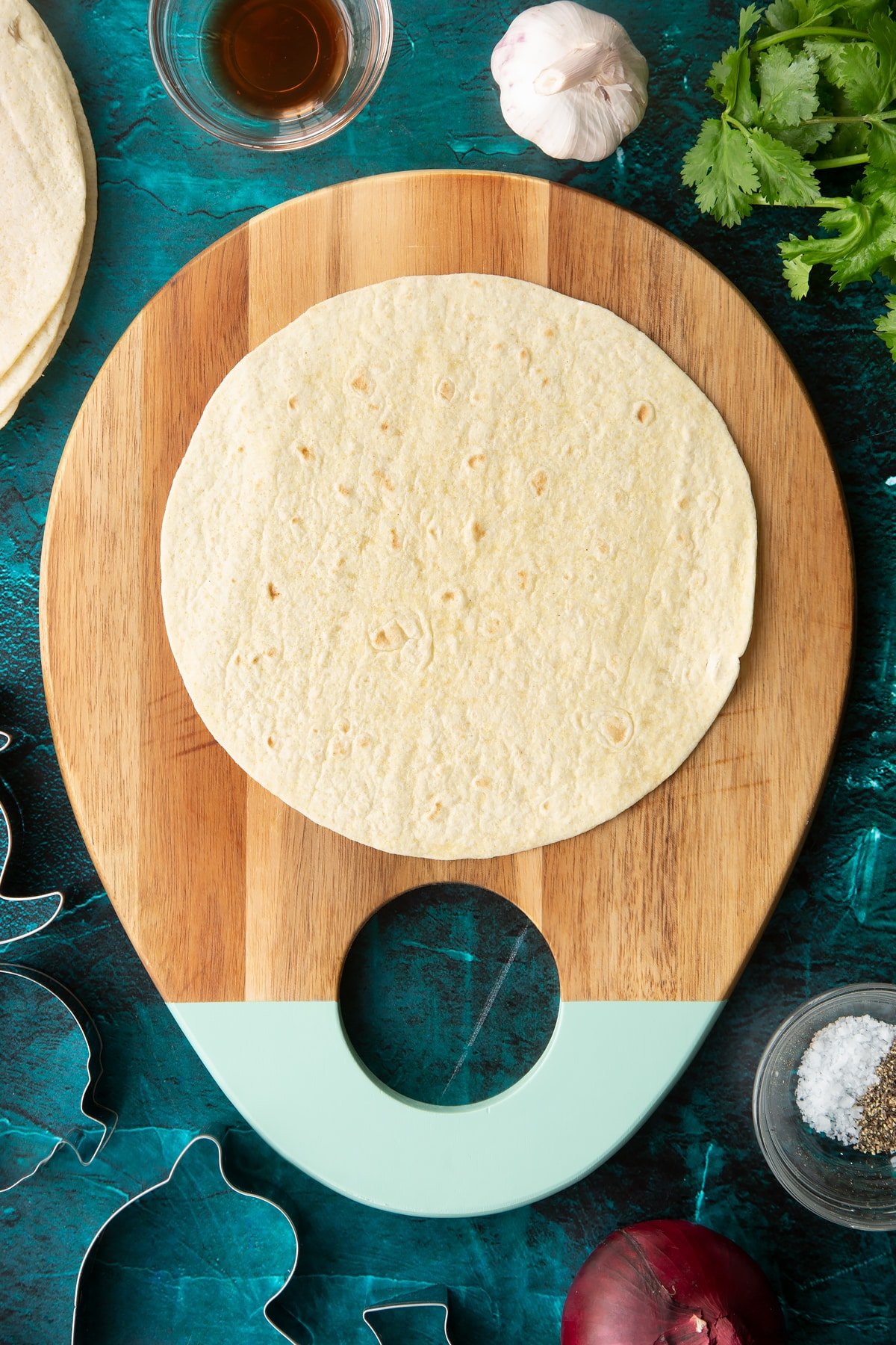 A soft, round tortilla on a board.