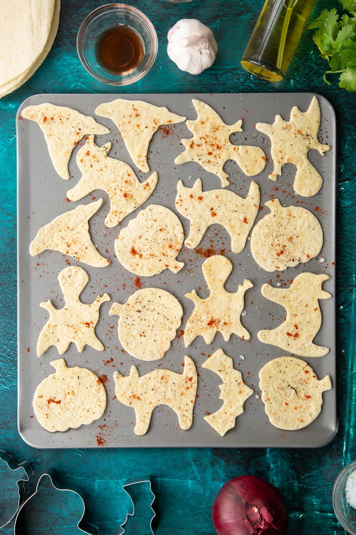 Soft Halloween tortillas on a baking tray, sprinkled with salt, pepper and paprika.