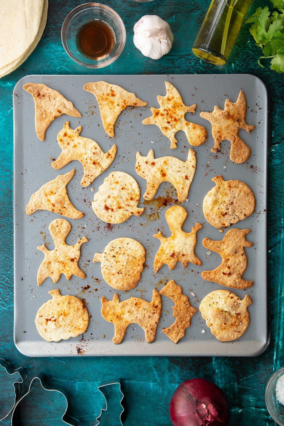 Baked Halloween tortillas on a baking tray, sprinkled with salt, pepper and paprika.