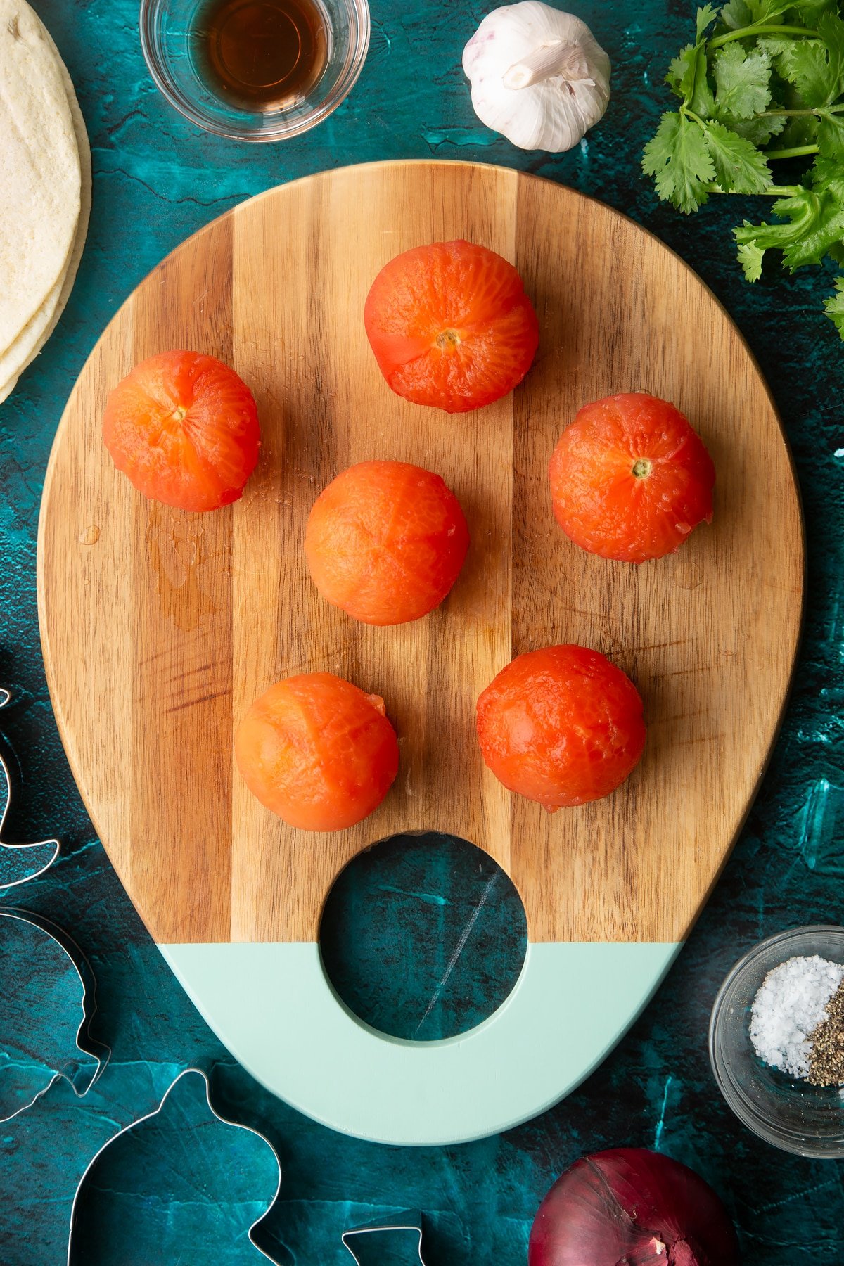 Peeled tomatoes on a wooden board.