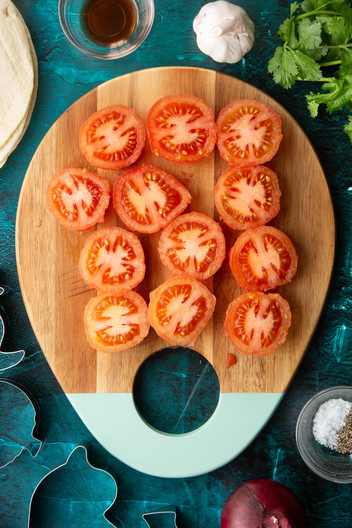 Peeled tomatoes, cut in half on a wooden board.